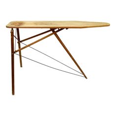 a wooden table with metal legs and an ironing board on it's top