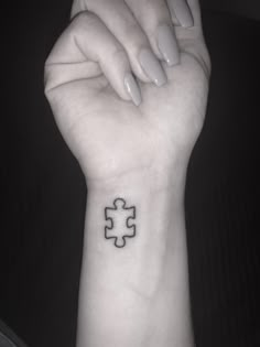 a woman's arm with a tattoo on it that has a puzzle piece in the middle