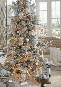 a decorated christmas tree with silver and white ornaments