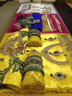 a table topped with lots of different types of bracelets and necklaces on display