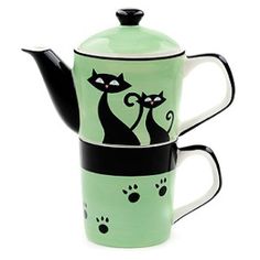 two teapots with cats painted on them are sitting next to each other in front of a white background