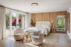 a bedroom with wooden paneling and sliding glass doors leading to the outside patio area