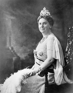 an old black and white photo of a woman wearing a tiara sitting in a chair