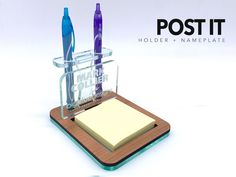 a pen holder with two pens and a notepad on it that says post - it