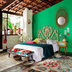 a bedroom with green walls and wooden ceiling