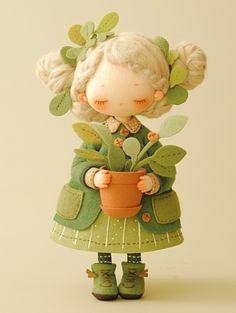 a little doll holding a potted plant