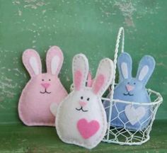 three felt bunnies in the shape of rabbits sitting next to each other on a shelf