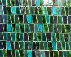 a close up view of green and blue glass tiles