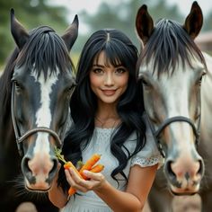 a woman standing next to two horses holding carrots in each hand and looking at the camera