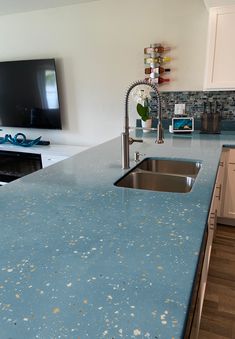 a blue counter top in a kitchen next to a tv