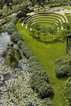 an aerial view of a circular garden with benches and water lilies in the foreground