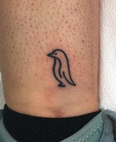 a small penguin tattoo on the ankle