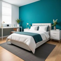 a bedroom with teal walls and white furniture in the corner, along with a large bed