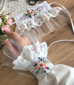 two white garters with flowers on them sitting on top of a wooden table