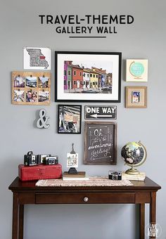 a table with some pictures on it and a red suitcase sitting next to the desk