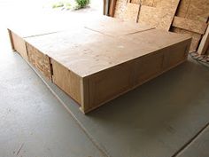 a large wooden box sitting in the middle of a room filled with plywood boards