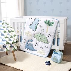 a baby crib bedding set with dinosaurs on it