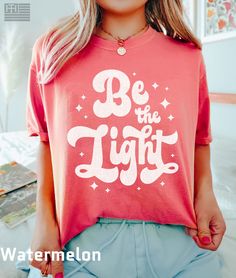 "PRODUCTION TIME: 1-3 days (Usually 2 days) SHIPPING TIME: 2-5 days (Usually 3 days) 👕PRODUCT DESCRIPTION👕 Illuminate your path and uplift those around you with our \"Be the light\" t-shirt, inspired by Matthew 5:14. Spread love and positivity with this colorful Jesus shirt, designed for those who want to make a difference in the world. Our Christian T-Shirt is not only a must-have but also a great religious gift and bible verse shirt that reminds you to love like Jesus. Show your faith wherev Inspirational Pink Cotton T-shirt, Cute Red Shirt With Letter Print, Inspirational Pink Crew Neck Top, Inspirational Pink Tops With Text Print, Pink Cotton Inspirational T-shirt, Inspirational Pink T-shirt With Text Print, Bridesmaid Bachelorette, Bridesmaid Shirt, Shirts Trendy