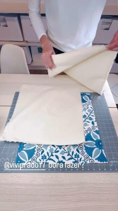 a person cutting fabric on top of a table