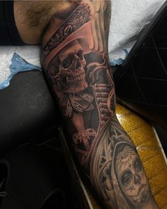 a man with a tattoo on his arm holding a clock and skull wearing a top hat