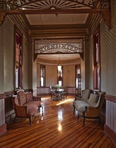 an ornately decorated living room with wood floors and high ceilings, is pictured in this image