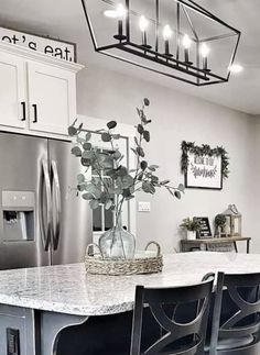 a kitchen with white cabinets and black chairs