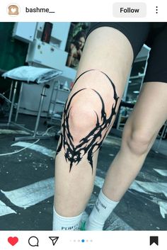 a person with a tattoo on their leg and the legs are covered in black ink