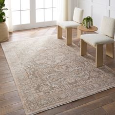 a beige rug with two chairs and a table