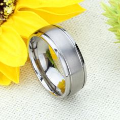 a yellow flower sitting next to a silver ring