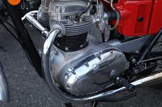 the engine of an old style motorcycle is shown in this image, with red and black trim