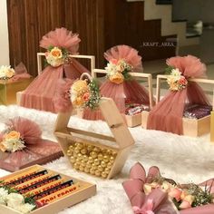 a table topped with lots of boxes filled with flowers and candies on top of a white rug