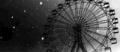 an old ferris wheel in the snow at night