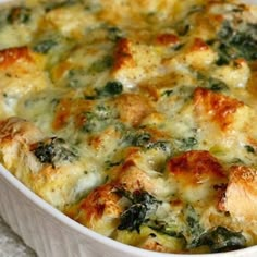 a casserole dish with chicken, spinach and cheese in it on a table