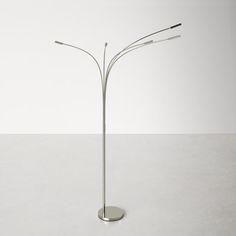 a metal floor lamp with three lights on each side and one light in the middle