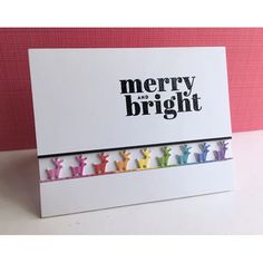 a card with the words merry and bright written on it in rainbow colored figures, against a pink background