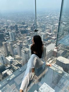 a woman standing on top of a tall building