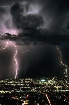 lightning strikes in the night sky over a city