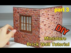 someone is building a miniature brick wall with windows and bars on the outside, part 3