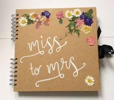 a brown notebook with flowers and the words miss to mrs written on it