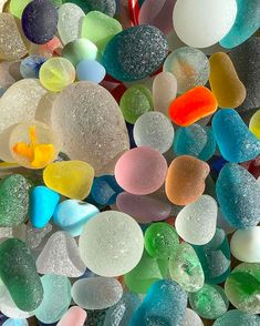 many different colored pieces of glass sitting on top of each other in the middle of a pile