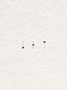 three black dots on white paper with one small dot in the middle and two smaller dots at the bottom