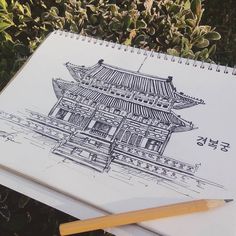 a notebook with a drawing of a chinese building on it and a pencil next to it