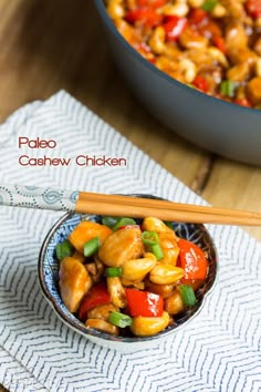 a bowl filled with cashew chicken and chopsticks next to a skillet