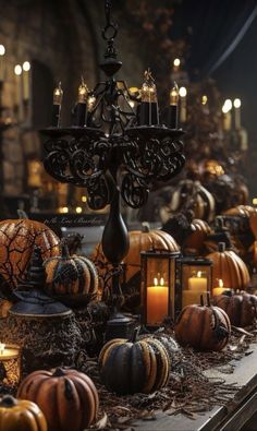 a table topped with lots of pumpkins and candles