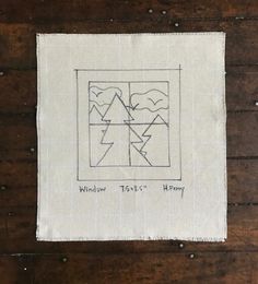 a piece of cloth on top of a wooden table with a drawing in the middle