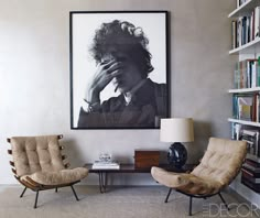 a living room with two chairs and a poster on the wall that says i'm not here