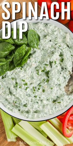 spinach dip in a white bowl surrounded by vegetables