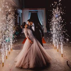 a newly married couple standing in front of fireworks