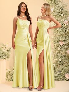 two women wearing yellow dresses standing next to each other in front of a floral backdrop