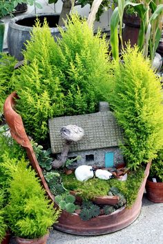 a potted planter filled with lots of plants and a small house in the middle